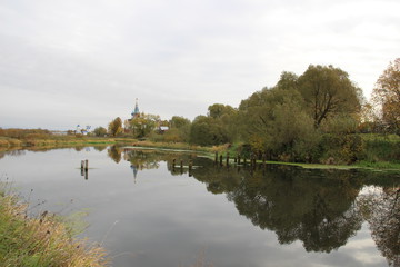 Landscape of Dunilovo village with church  and monastery on the river in cloudy fall day