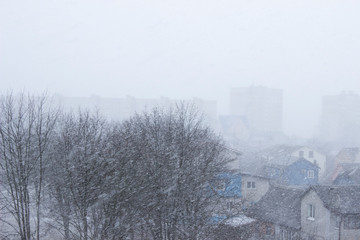 Strong wind and heavy snowfall blizzard in city at winter