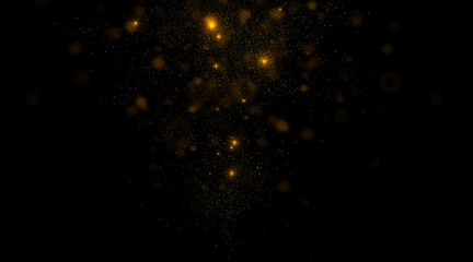 Glowing golden particles on black background. 