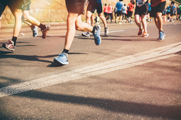 Marathon runners in the city. Blurred marathon background. Close up legs.