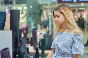 Closeup of a young happy woman shopping in fashion shoe store