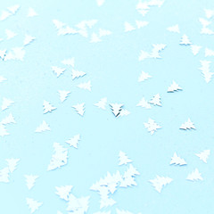 Silvery Christmas confetti on a blue background.