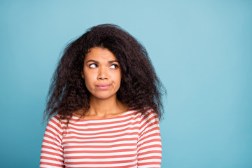 Fototapeta premium Photo of pretty dark skin lady looking empty space thinking over important decision have some doubts wear casual clothes isolated pastel blue color background