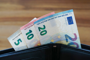 Different Euro banknotes in a black wallet