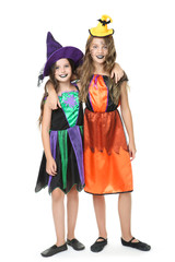 Two young girls in halloween costumes on white background