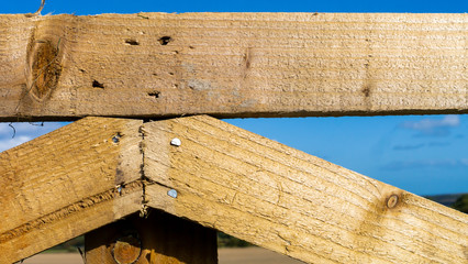 Treated wood fashioned into a interestingly shaped fence using nails.