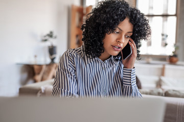 Young female entrepreneur talking with a client on her cellphone