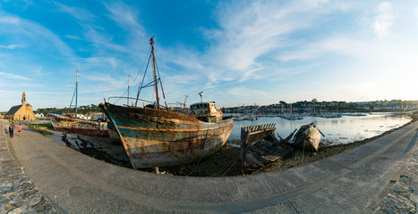 Fototapeta premium tourists visit the historic chapel and fishing boat wrecks in the harbor of Camaret-sur-Mer in Brittany