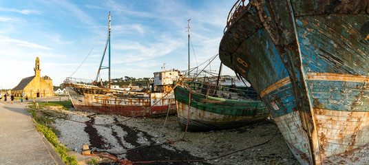 Fototapeta na wymiar tourists visit the historic chapel and fishing boat wrecks in the harbor of Camaret-sur-Mer in Brittany