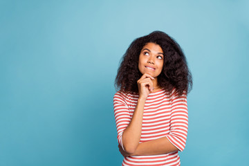 Photo of serious confused interested black millennial trying to remember important information biting her lips touching chin with hands isolated over blue color vivid background - obrazy, fototapety, plakaty