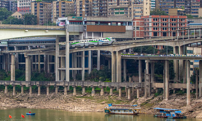 China. Monorail in the Chinese city of Chongqing. Niujiaotuo Subway Station, Yuzhong District. The Yuao Jialingjiang bridge over the Jialing River, transport, boats on the banks of the river.