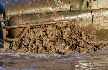 SUV wheel stalled in mud and water