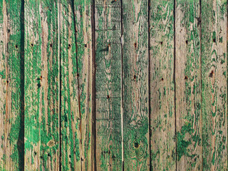 Fototapeta na wymiar Old wooden boards on a fence painted with green paint.