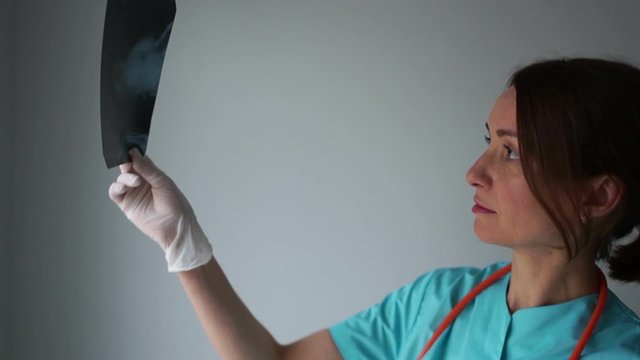 Young and nice doctor watching a patient x-ray in hospital. International doctors day, Diagnostician female doctor