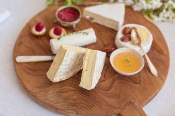 Cheese plate, a festive snack of different types of cheeses, honey, nuts and berries
