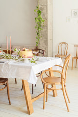 Fototapeta na wymiar Bridal wedding table with cake, candle, champagne and snacks