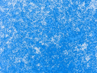 Fototapeta na wymiar Abstract background. Melted and crystallized snow on a blue surface. Top view