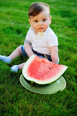 beautiful little boy eats ripe watermelon on the nature