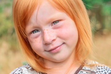 Fototapeta premium Portrait of a beautiful red-haired girl with freckles