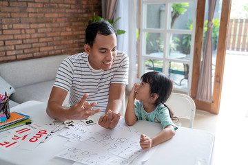 toddler learning math and counting with her father at home together