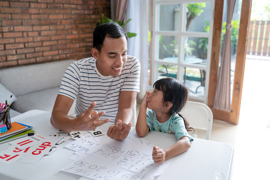toddler learning math and counting with her father at home together