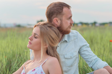 Love story of the beautiful bearded man  and woman on green summer meadow
