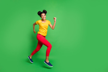 Fototapeta na wymiar Full size profile photo of pretty dark skin lady jumping high sports competition jogging participant wear casual yellow t-shirt red pants isolated green background