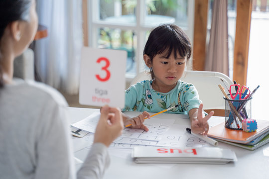 parent showing number on a flash card during studying at home