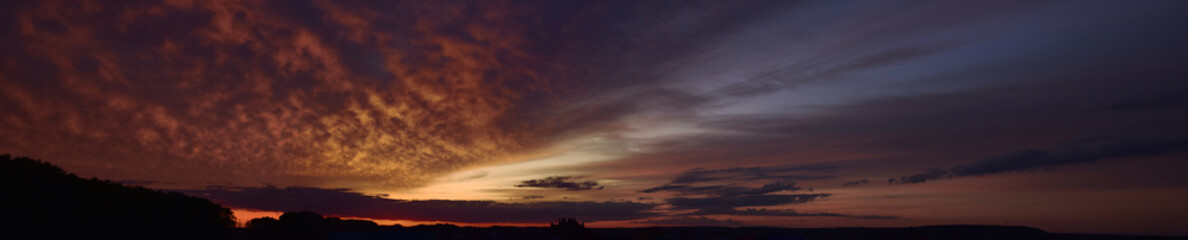 Evening, summer sunset. Panoramic photo, late afternoon, alarming, red sunset.