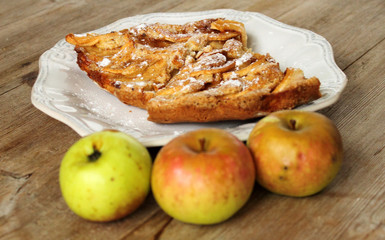 Autumn homemade apple pie - charlotte. on white ceramic plate on wooden background with fresh apples