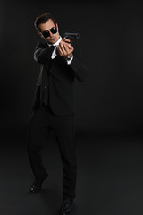 Male security guard in uniform with gun on dark background