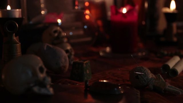 close-up of a well-decorated witch's altar with a change of focus from the skull to the candle. Halloween decoration