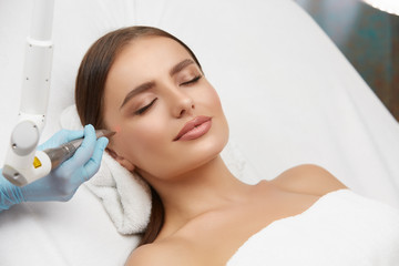 Fototapeta na wymiar Cosmetology. Closeup Of Female Face having facial treatment in beauty salon. Cosmetic procedures in spa clinic.