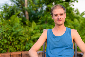 Naklejka na ściany i meble Young handsome man with blond hair relaxing outdoors