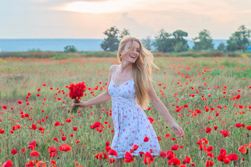 beautiful blonde girl running through the poppy field
