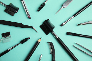 Set of professional eyebrow tools on turquoise background, flat lay