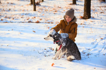 Boy playing with husky in winter park