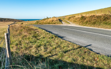 Rural English country lane. The road over the South Downs (East Sussex, England) leading to the English Channel coastline and Birling Gap. - 294667430