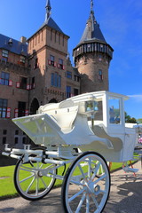 White carriage in front of a beautiful castle. 