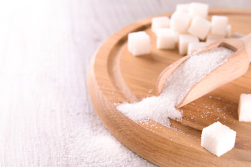 Fototapeta na wymiar White cane sugar on a light wooden background