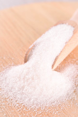 White cane sugar on a light wooden background