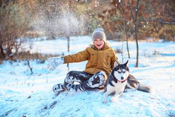 Boy is playing with husky dog in winter park © iwavephoto