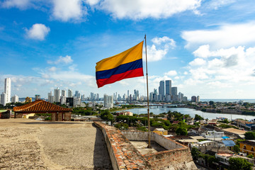 Bandera de Colombia en el Castillo de San Felipe y la ciudad moderna de Cartagena al fondo