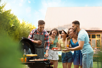 Group of friends with drinks near barbecue grill outdoors
