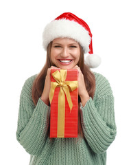 Happy young woman in Santa hat with Christmas gift on white background