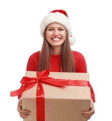 Happy young woman in Santa hat with Christmas gift on white background