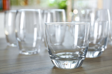 Empty glasses on wooden table against blurred background