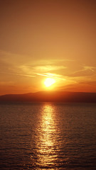 Fototapeta na wymiar Photo of beautiful cloudy sunset with golden colours over the Aegean sea