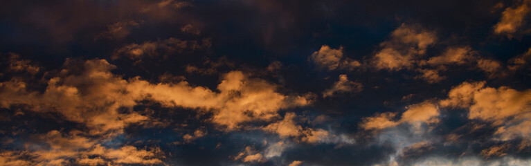 Obraz premium Dramatic sky at sunset or sunrise with red and orange clouds. Variegated colored clouds at the evening sunset of the summer sky.