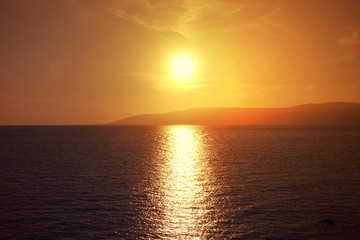 Photo of beautiful cloudy sunset with golden colours over the Aegean sea